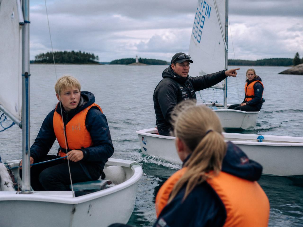 Young sailors in life vests learning to sail dinghies